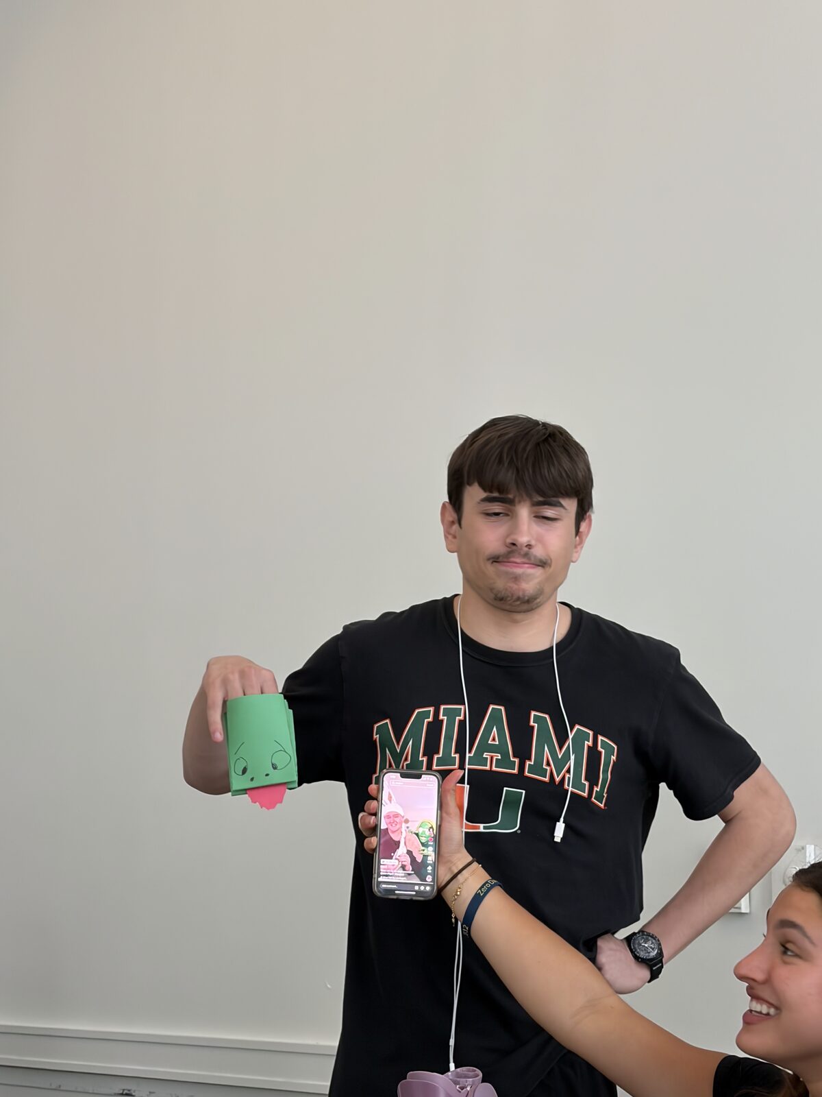 A brother in a Miami shirt holding a handmade card